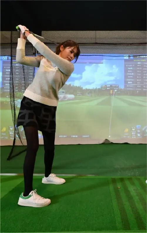 シミュレーションゴルフを使う女性ゴルファーの様子