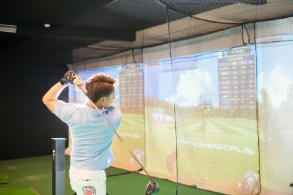 シミュレーションゴルフでゴルフ練習をする様子