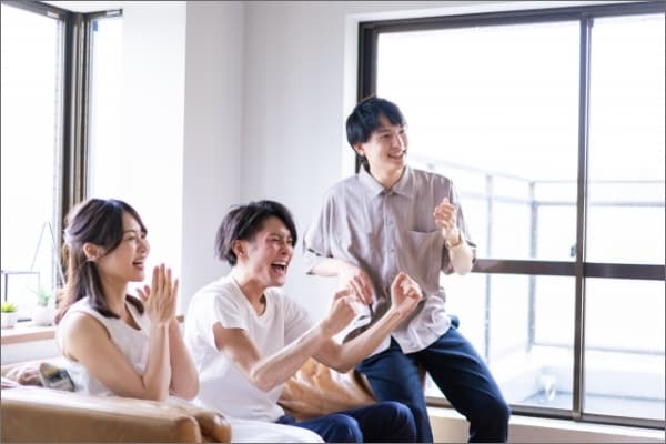 自宅のシミュレーションゴルフで家族が盛り上げる様子